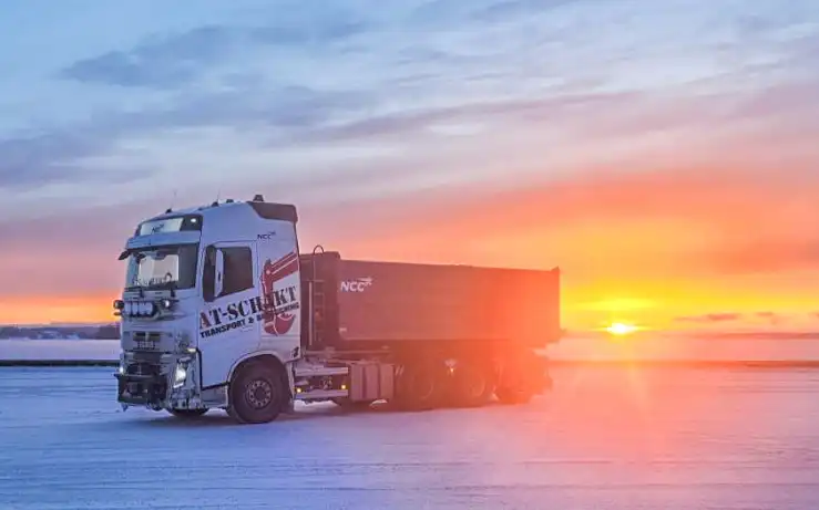Lastbil som transporterar material i solnedgången